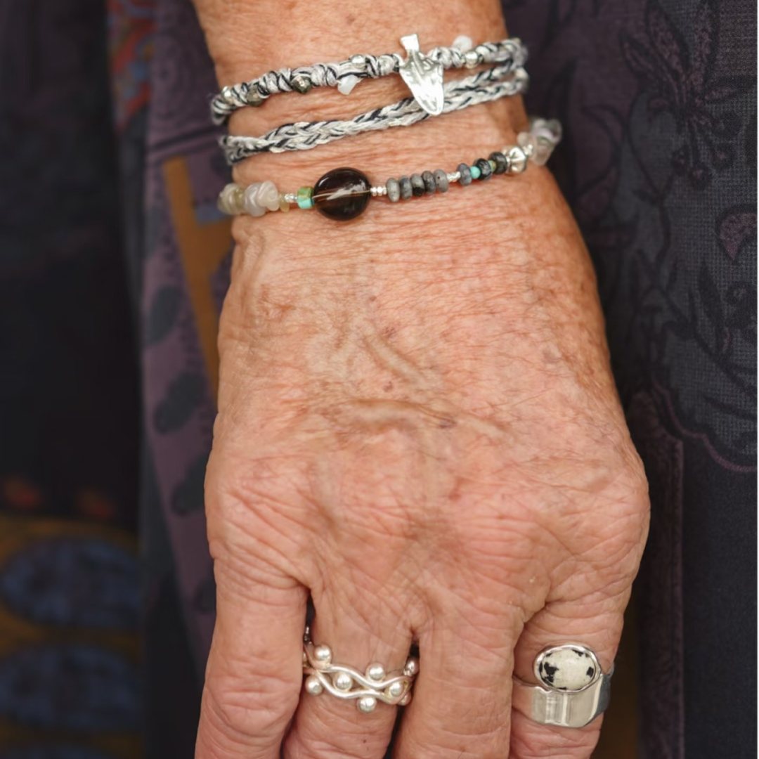 Wrap & Wander, hand-knotted shell and pyrite cord wrapped as a bracelet, worn on the hand