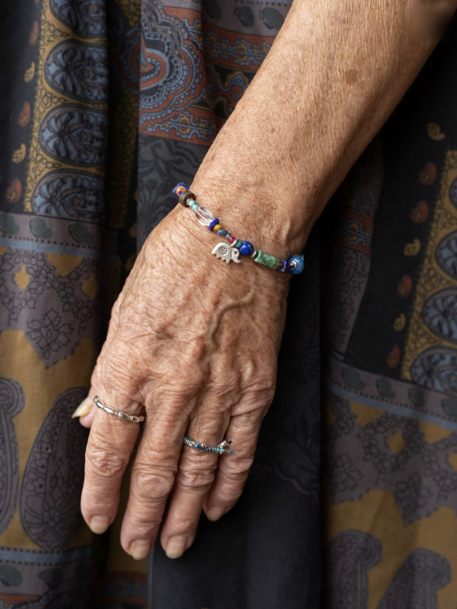 Grandma's wrist on a paisley skirt wearing the Star-Keeper Elephant bracelet